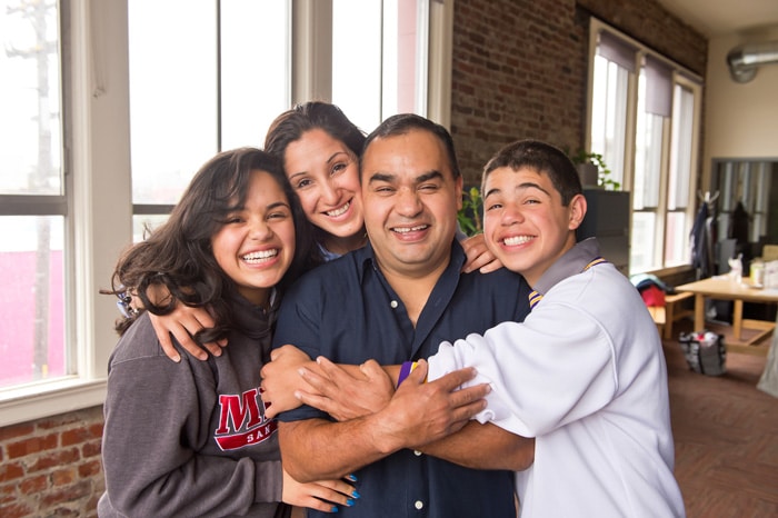 Happy homeowner family hugging in their living room